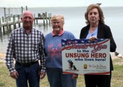 Jeannie and Doug Ping Receive Unsung Hero Lives Here Yard Sign - We Can